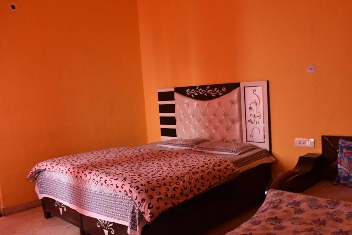 Un dormitorio con una cama, una mesita de noche y una silla.
