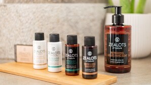 A selection of ZEALOTS of nature products including body milk, conditioner, shampoo, and hand soap on a wooden surface. - Executive Apartment With Private Terrace-d (Piraeus)