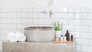 A bathroom with a stone sink, a mirror, and toiletries on a wooden tray. - Executive Apartment With Private Terrace-d (Piraeus)