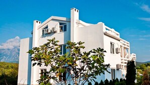 Un edificio moderno blanco con techo plano, ventanas amplias y una chimenea visible.