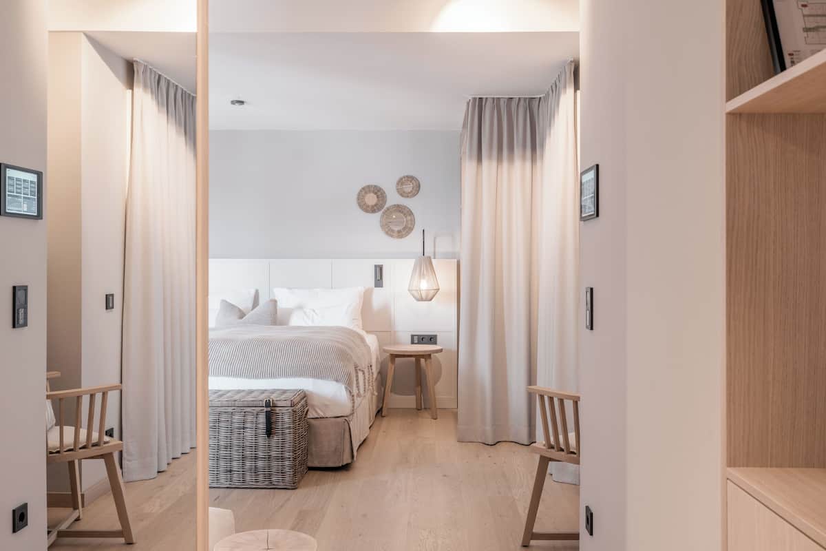Un dormitorio moderno con cama, mesitas de noche y una lámpara.