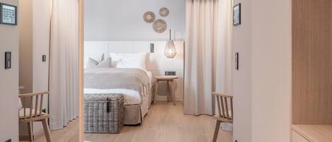 A modern bedroom with a bed, bedside tables, and a lamp.