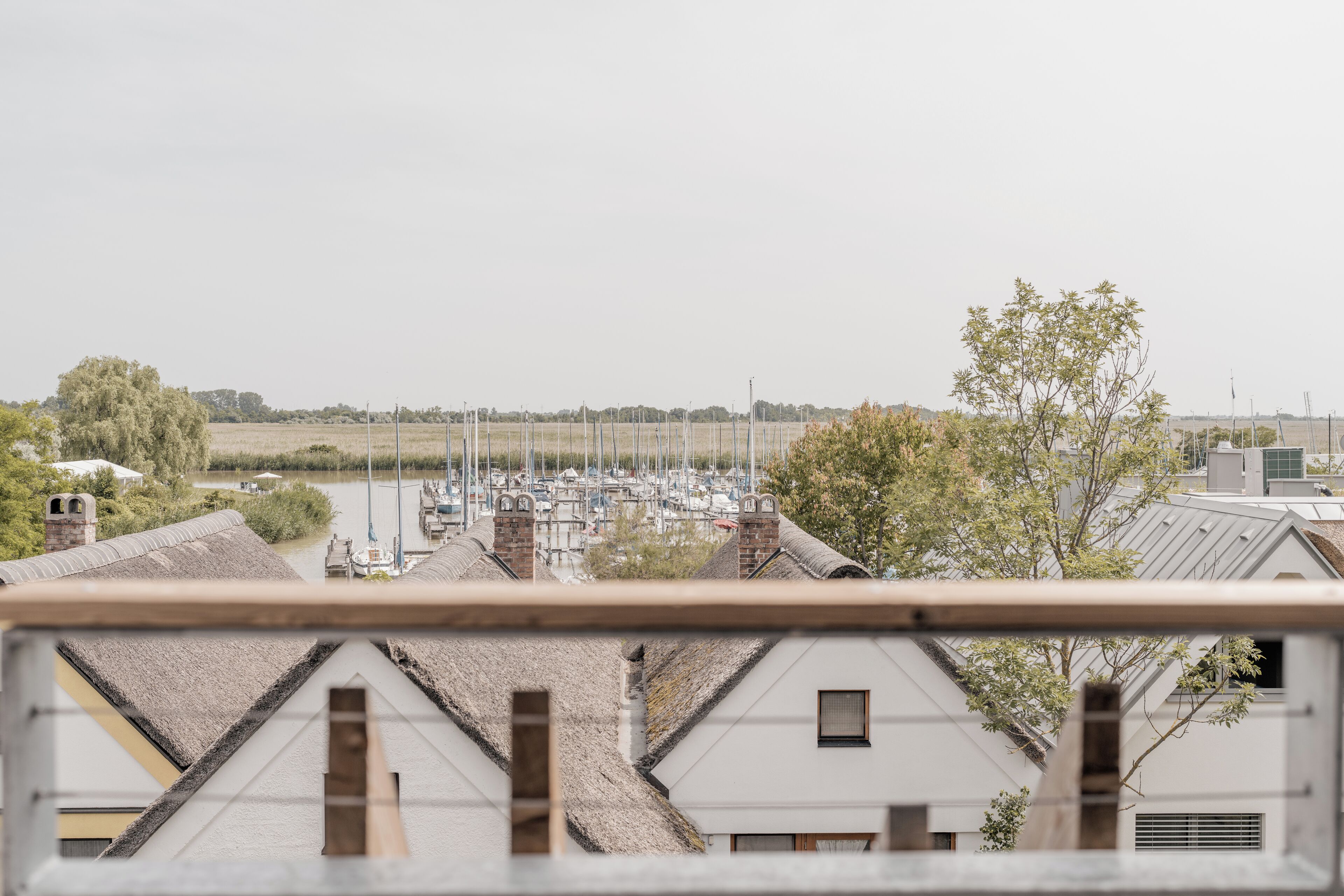 Un port de plaisance où sont amarrés des bateaux, entouré d’immeubles d’habitation aux toits inclinés.