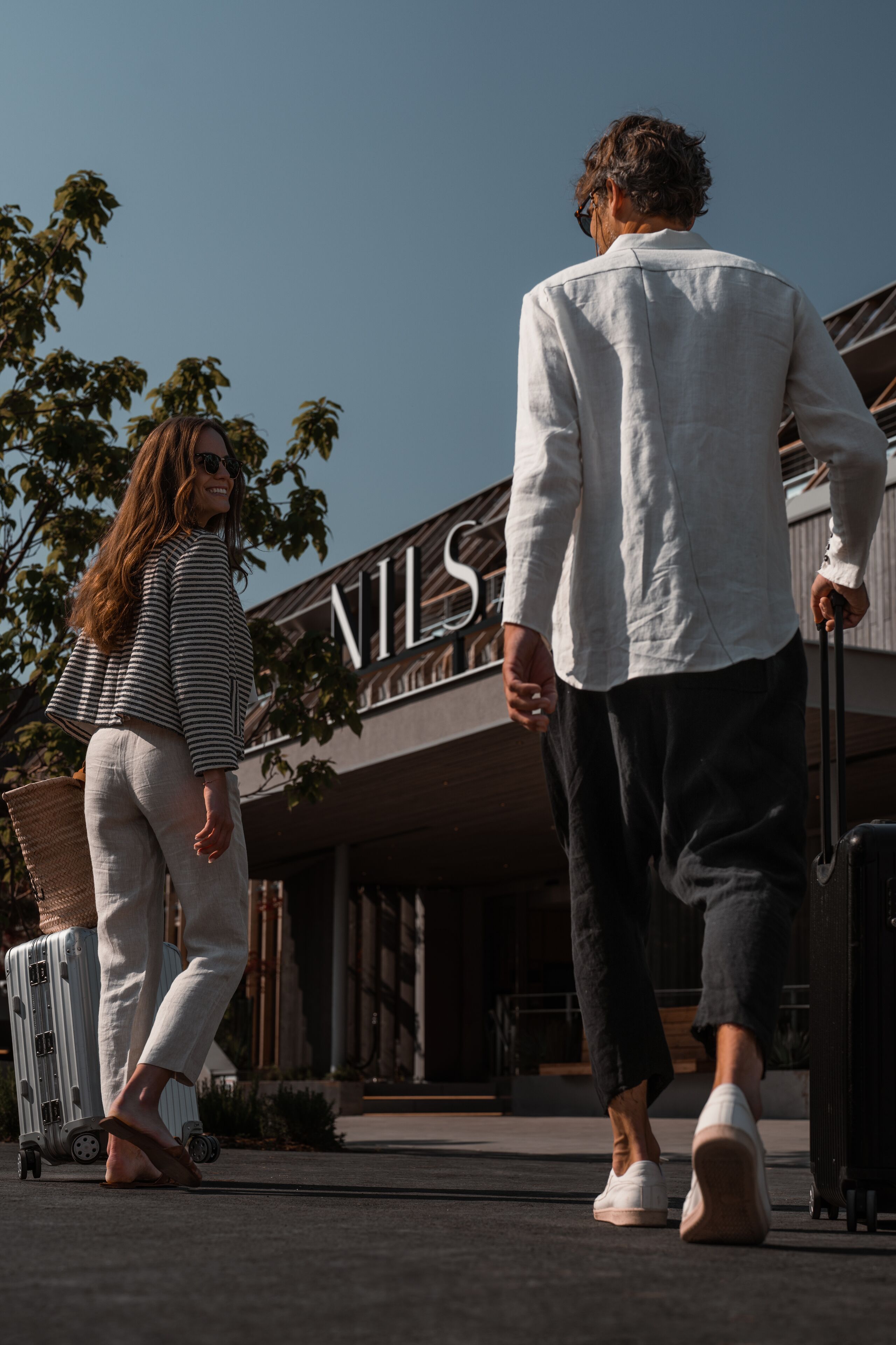 Dos personas caminando hacia un edificio con el letrero "NILS".