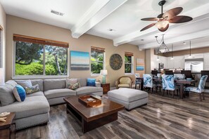 Relax in this stylish living area with a large sectional sofa, coffee table, and dining space.
