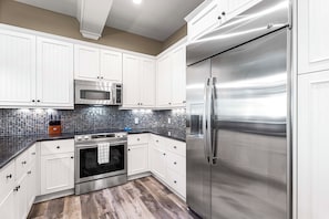 Enjoy cooking in this well-equipped kitchen with appliances, microwave, oven, and refrigerator.