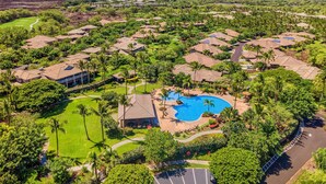 An aerial view of a resort with multiple bungalow-style buildings, a central swimming pool, and lush greenery. - 🏖️Kulalani Townhome w/ Mountain Views + Beach Club Access (Kamuela)
