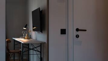 Een moderne kamer met een bureau, stoel en een wandgemonteerde televisie.