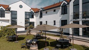 Edificio moderno con patio que ofrece asientos exteriores y sombrillas.