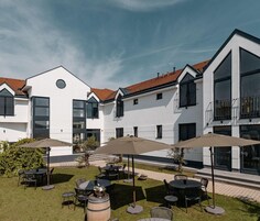 Edificio moderno con patio que ofrece asientos exteriores y sombrillas.