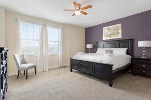 Cozy retreat with a large bed, nightstands, and a ceiling fan, offering a comfortable space to rest.