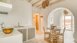 Cocina moderna con isla integrada, armarios grises y un cuenco de fruta en la encimera.
