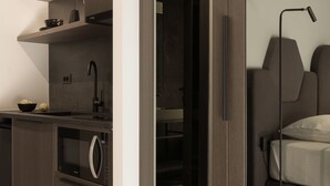 Quarto moderno com cama, mesa de cabeceira e espelho.