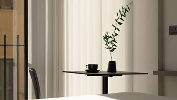 Una habitación moderna con una mesa, una planta en maceta y una taza.