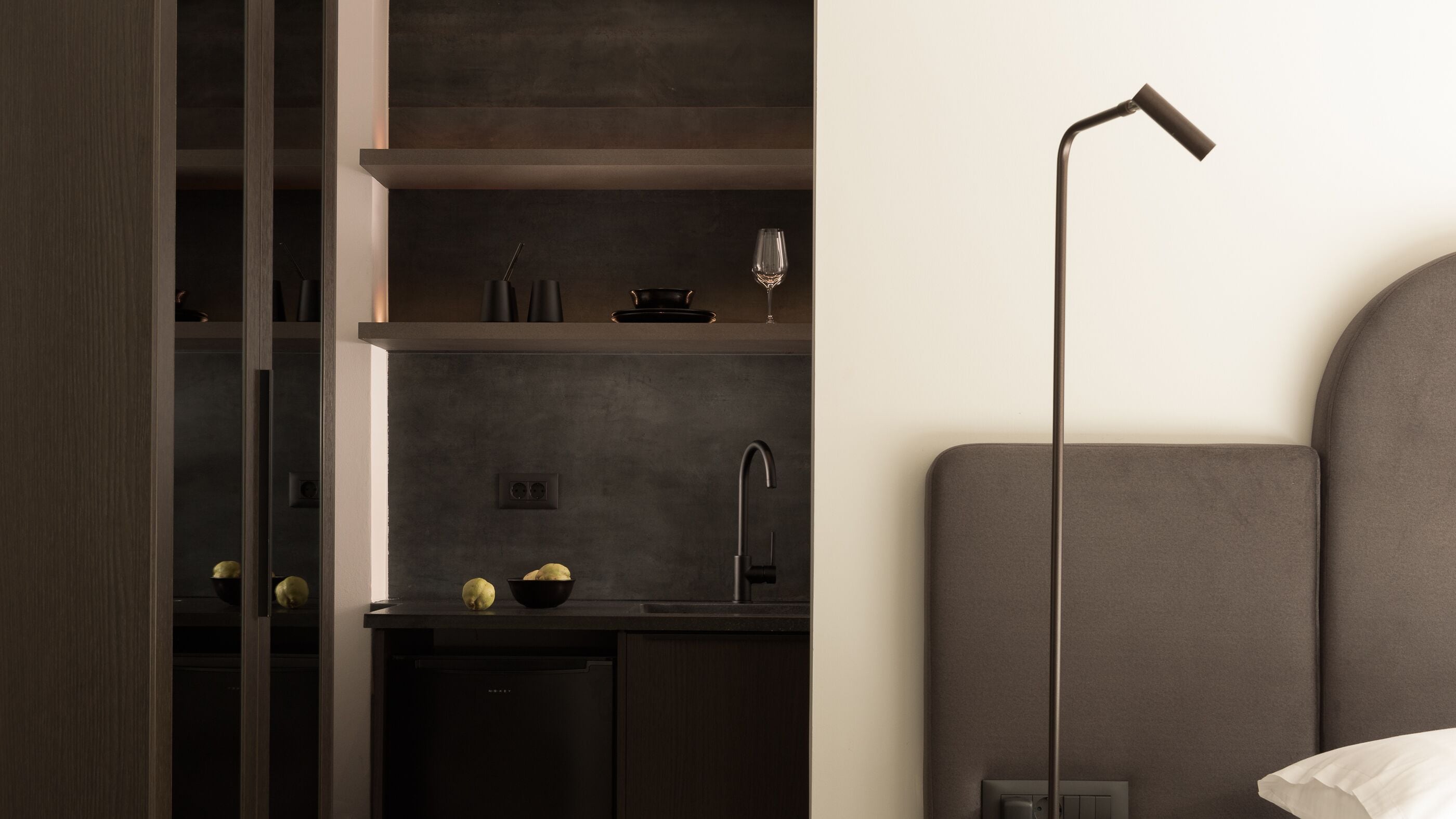 Una cocina moderna con armarios oscuros, un lavamanos integrado y un diseño minimalista.