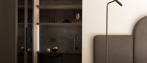 A modern kitchen with dark cabinetry, a built-in sink, and a minimalist design.