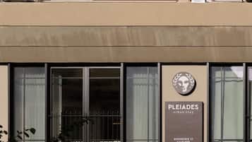 Un edificio con un letrero que dice "PLEIADES urban stay" y "BIKEOSINIS 21, PRIMER PISO".