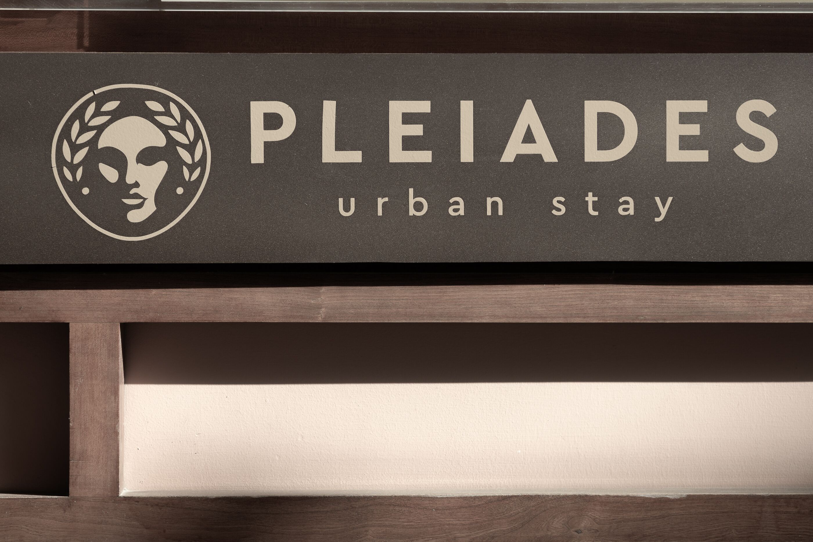 A sign with the text "PLEIADES urban stay" and a logo.