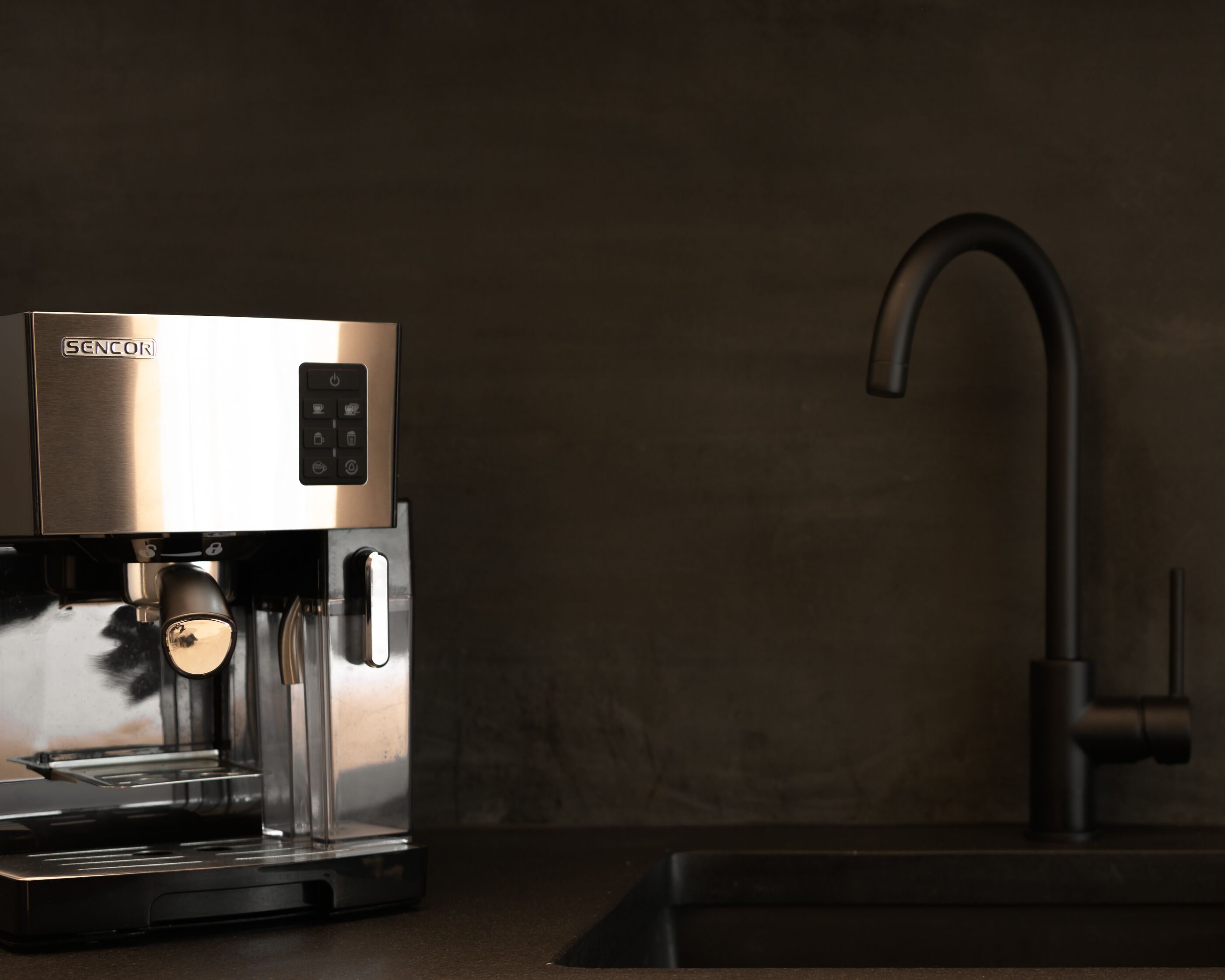 A modern espresso machine with a control panel and a sleek faucet.