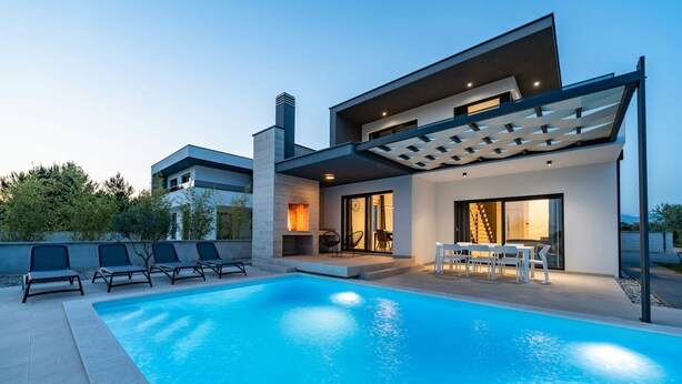 A modern house with a swimming pool, outdoor seating, and a covered patio area. - Villa Marita (Privlaka)