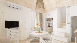 Una cocina moderna con armarios blancos, horno empotrado y un amplio ventanal.
