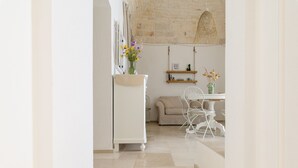 Una cocina moderna con un armario blanco, un jarrón con flores y una lámpara colgante.