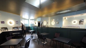 A restaurant interior with tables, chairs, and a counter. - Hotel Verisima (Tbilisi)