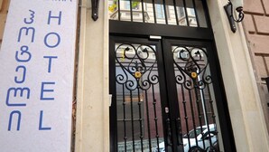 A hotel entrance with a black wrought iron gate and a sign indicating the hotel name and room number. - Hotel Verisima (Tbilisi)