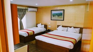 A hotel room with two beds, a wooden headboard, a mounted picture, and an air conditioning unit. - MeroStay 195  Hotel Garden  Pvt Ltd (Kathmandu)