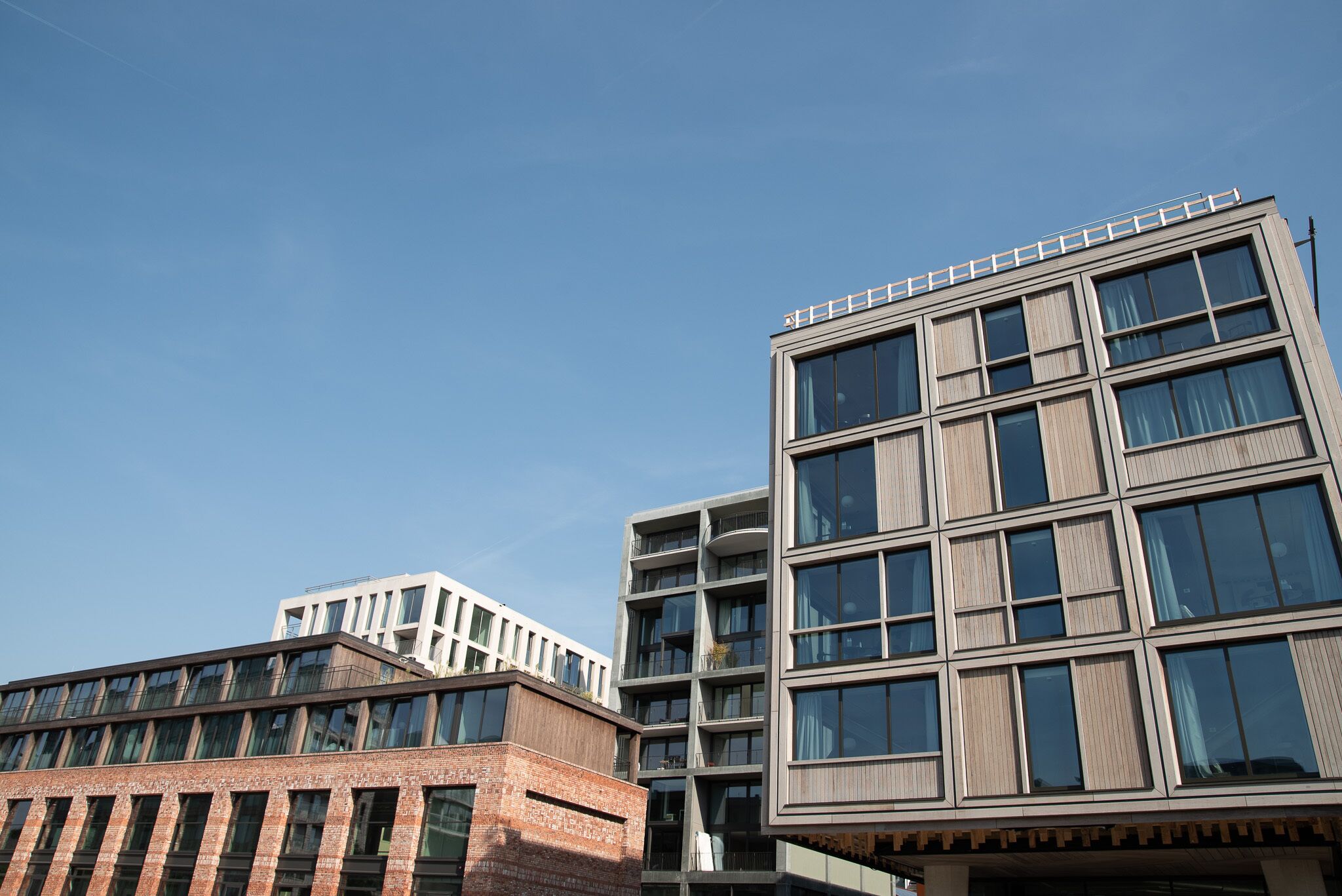 A modern building with multiple floors, large windows, and a flat roof.