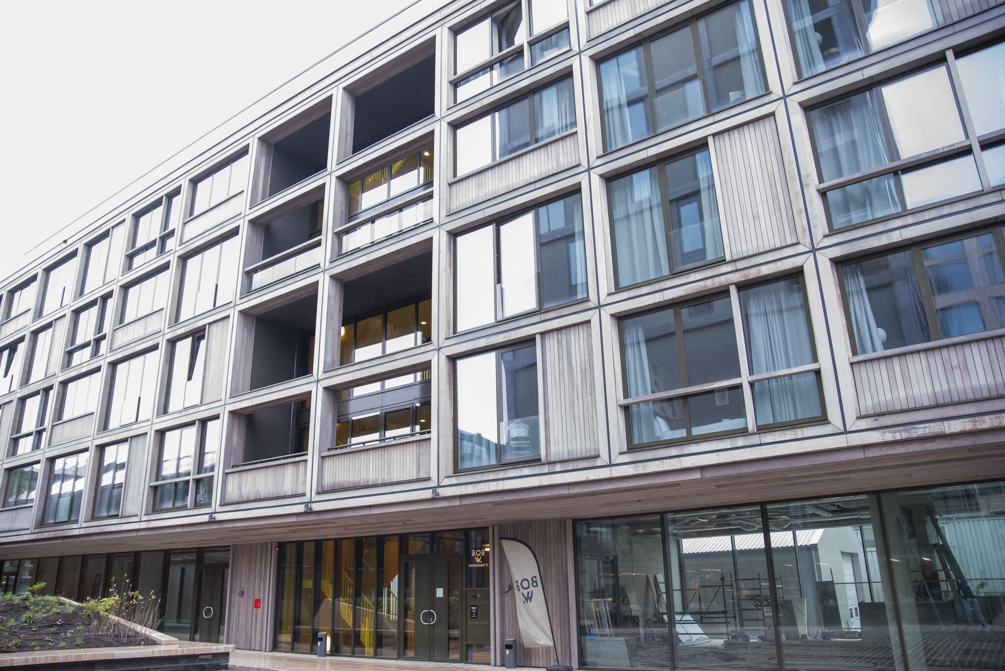 A modern multi-story building with large windows and a flat facade.