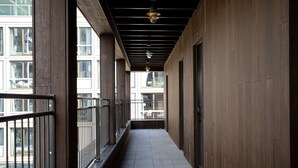 A corridor with wooden walls, metal railings, and tiled flooring. - Bob W Amsterdam Noord (Amsterdam)