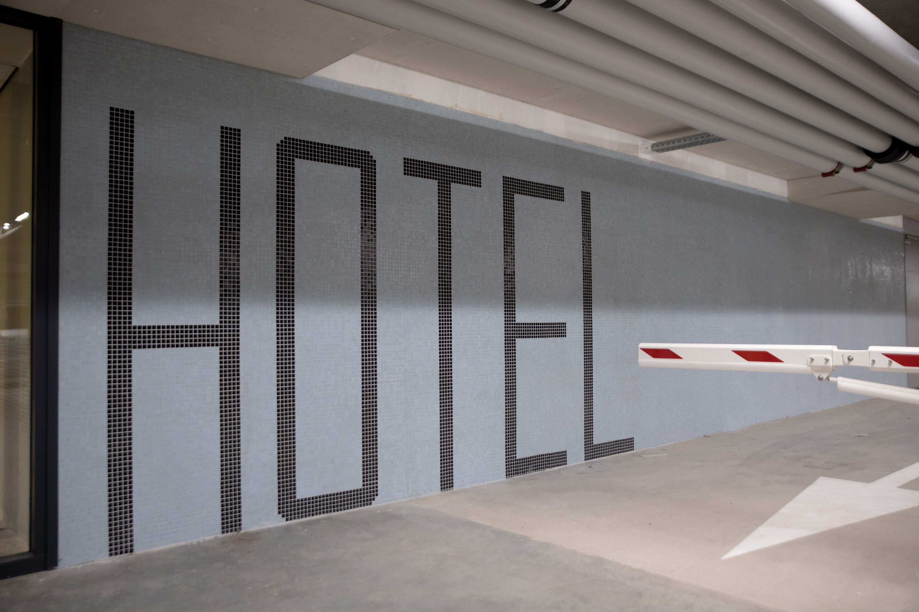 Eine Wand mit dem Wort „HOTEL“ in großen, mit Fliesen versehenen Buchstaben.