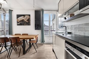 A modern kitchen with a dining area, large windows, and a city view. - Place des Vosges, 2BR/2BA, 4 people (París)