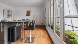 Et moderne køkken med spiseplads, store vinduer og udsigt til grøn natur.