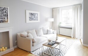 Ein modernes Wohnzimmer mit einem weißen Sofa, einem Couchtisch und einem Kamin.