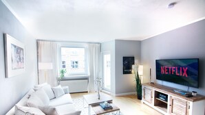 A modern living room with a sofa, coffee table, and TV. - Mediterranean design apartment I Central with cathedral view (Bremen)