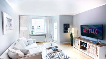 Ein modernes Wohnzimmer mit Sofa, Couchtisch und Fernseher.