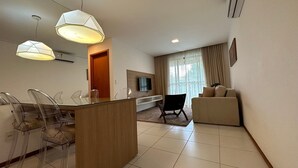 Une chambre d’hôtel moderne dotée d’un coin repas, d’un canapé et d’une télévision.