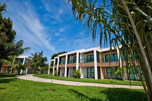 Un moderno edificio de varios pisos con techo plano, amplias ventanas y un césped bien cuidado.