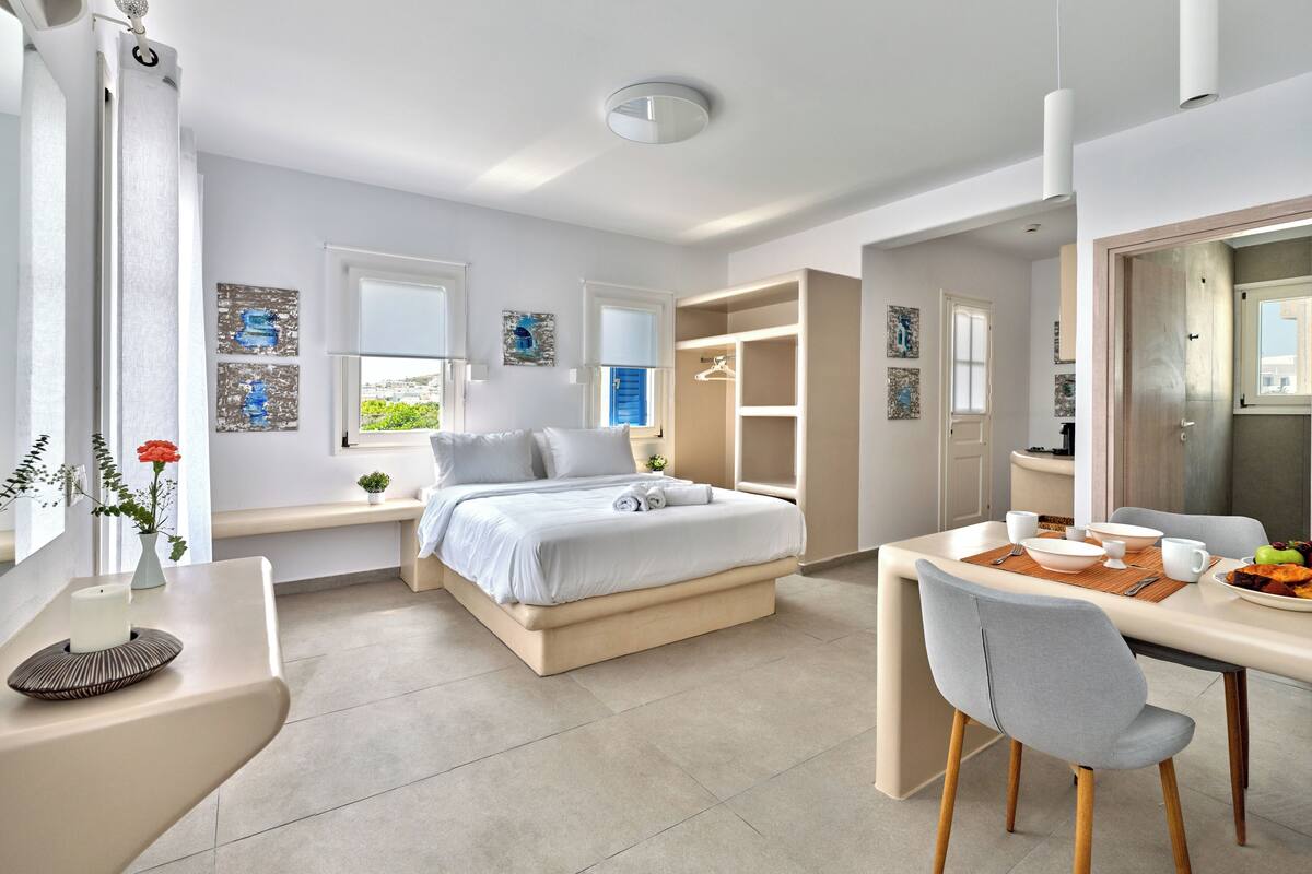 A modern bedroom with a bed, bedside tables, a desk, and a chair.