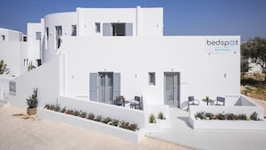 A modern white building with a sign reading 'bedspot Apartments.' - Bedspot Apartments Paros (Paros)