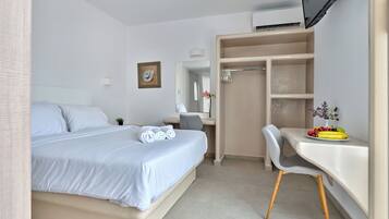 Ein Hotelzimmer mit Bett, Schreibtisch, Stuhl, Fernseher, Kleiderschrank und Bad.