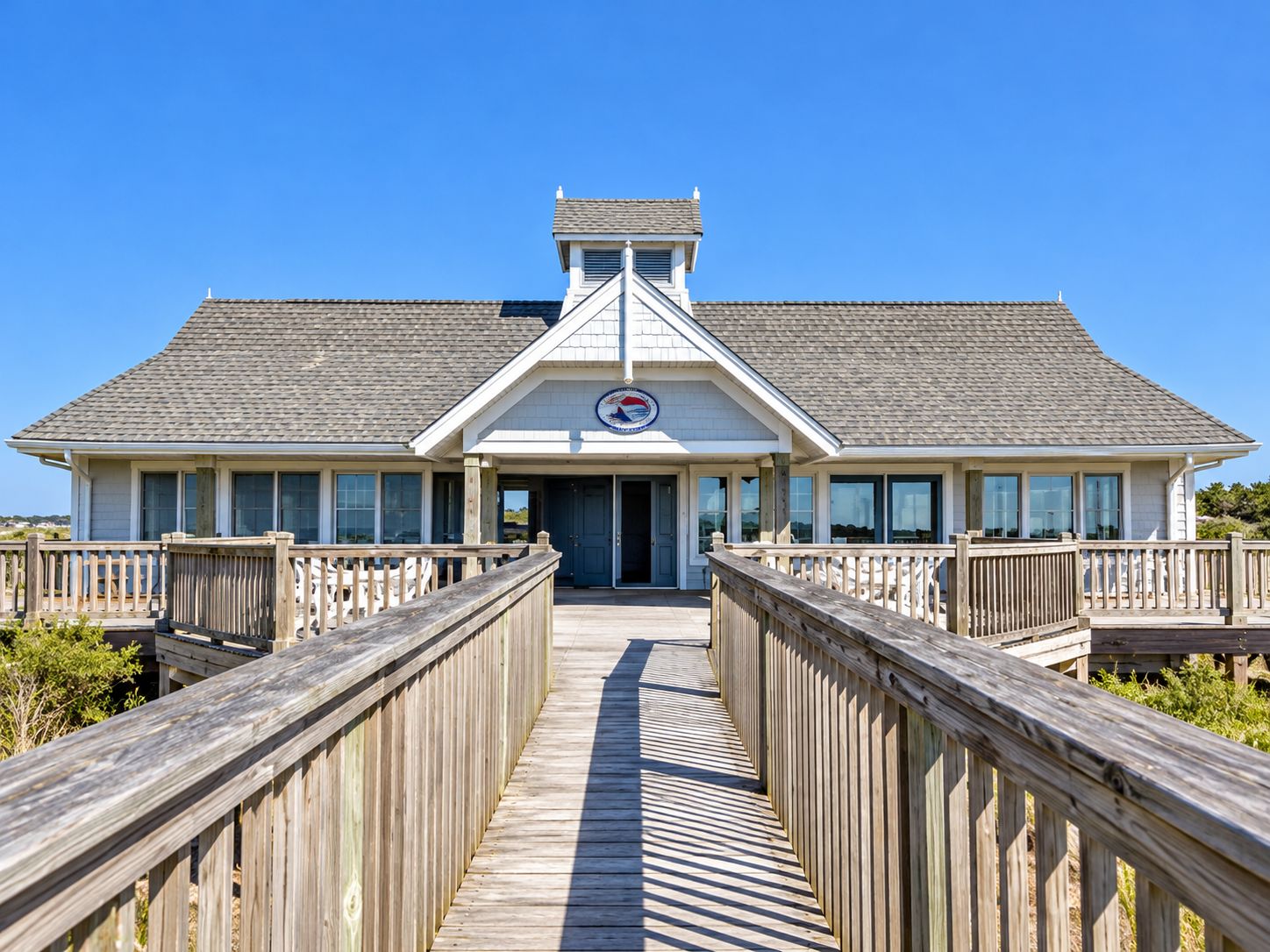 Un bâtiment situé en bord de mer, avec une allée couverte menant à l’entrée.
