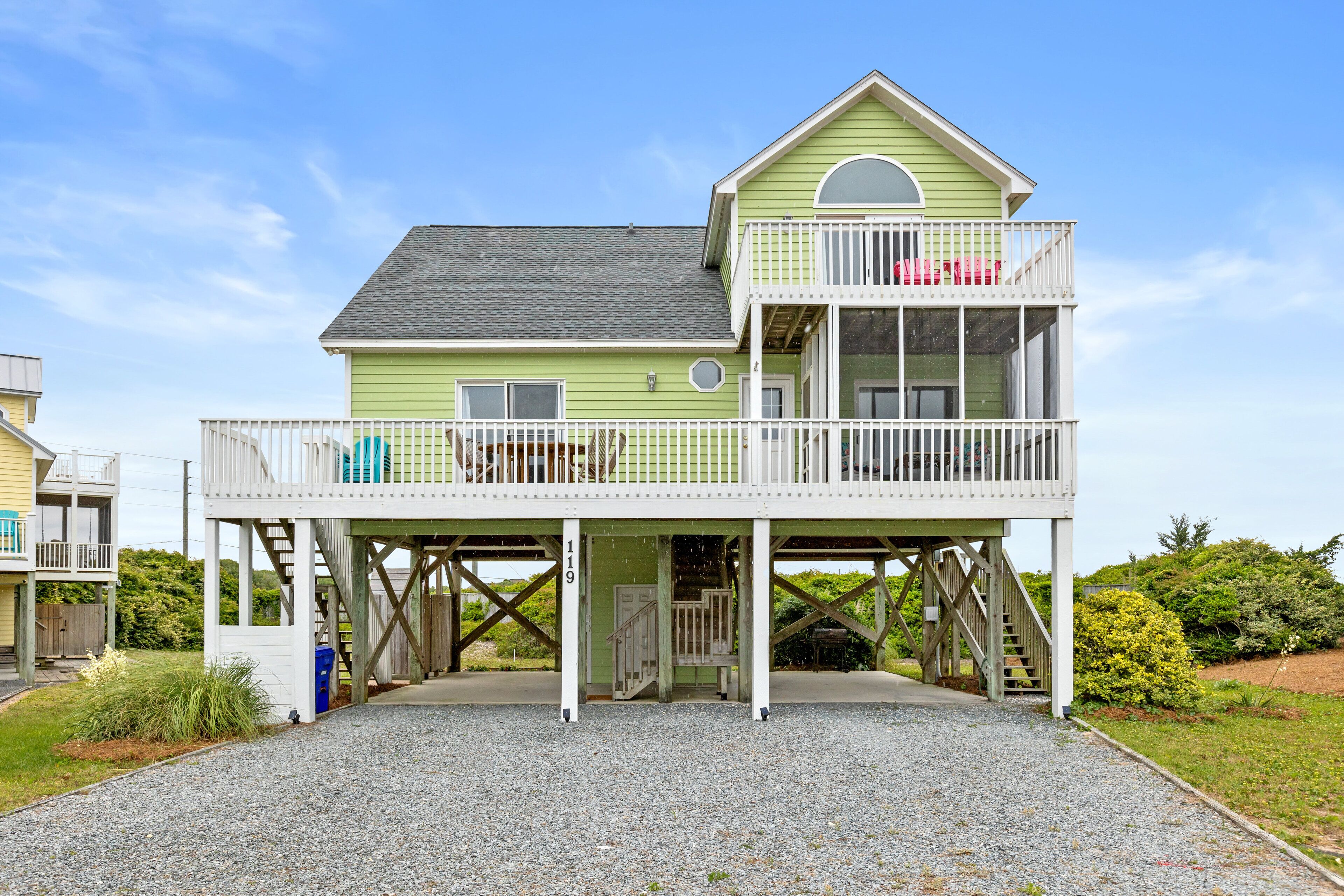A two-story house with a balcony and a covered porch.