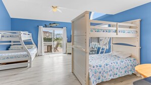 Una camera da letto con due letti a castello, una ventola a soffitto e vista sull'esterno.