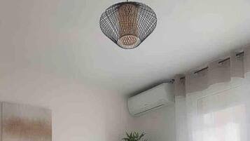 Una camera moderna con scrivania, sedia, pianta in vaso e lampadario.