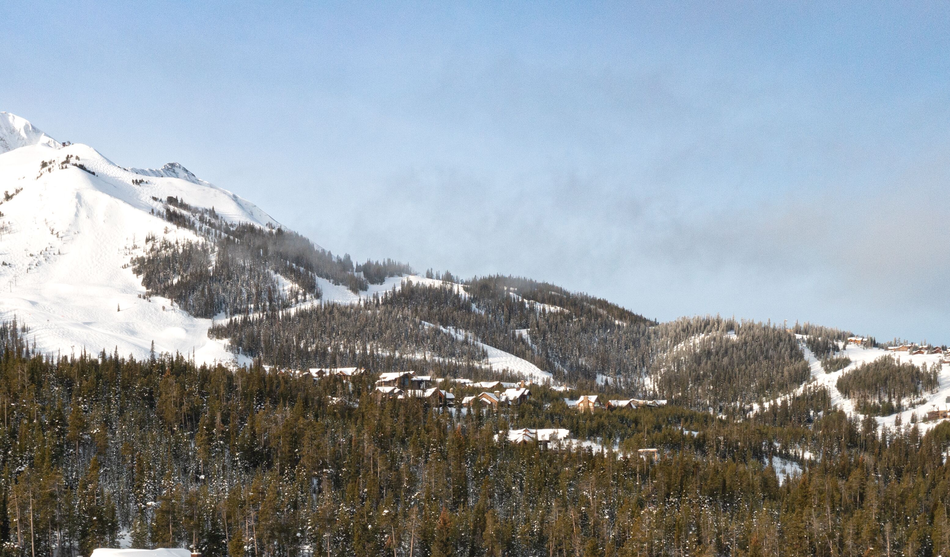A snow-covered mountain with a ski resort in the valley.