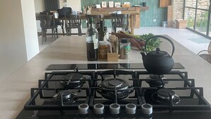A kitchen with a gas stove, hanging pendant lights, and a view of the dining area. - Traumhaftes Anwesen, Dorflage, am Fuße des Mt. Ventoux (Villes-sur-Auzon)