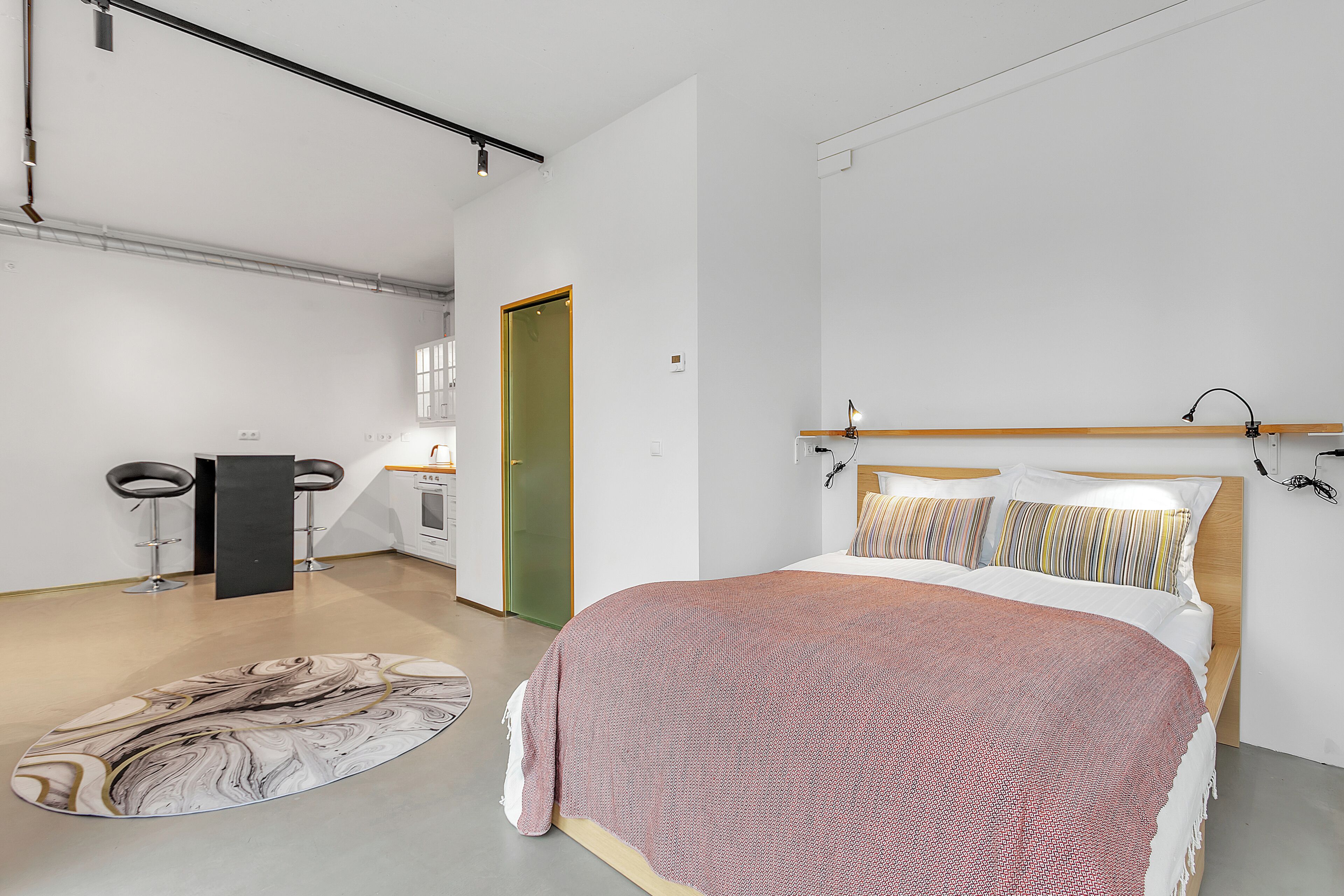 A modern bedroom with a large bed, a small desk, and a chair.